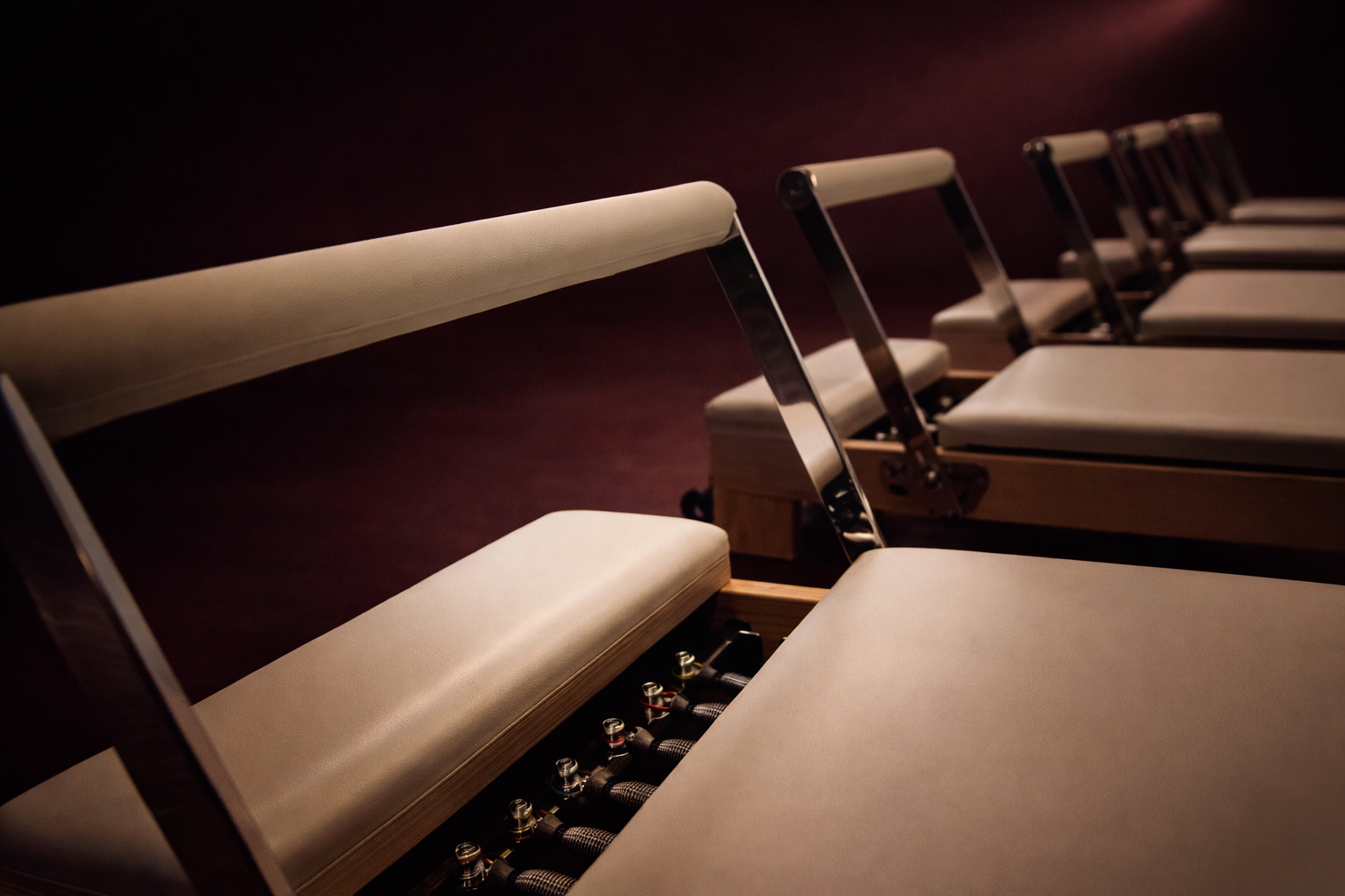 Row of reformer beds in moody lighting